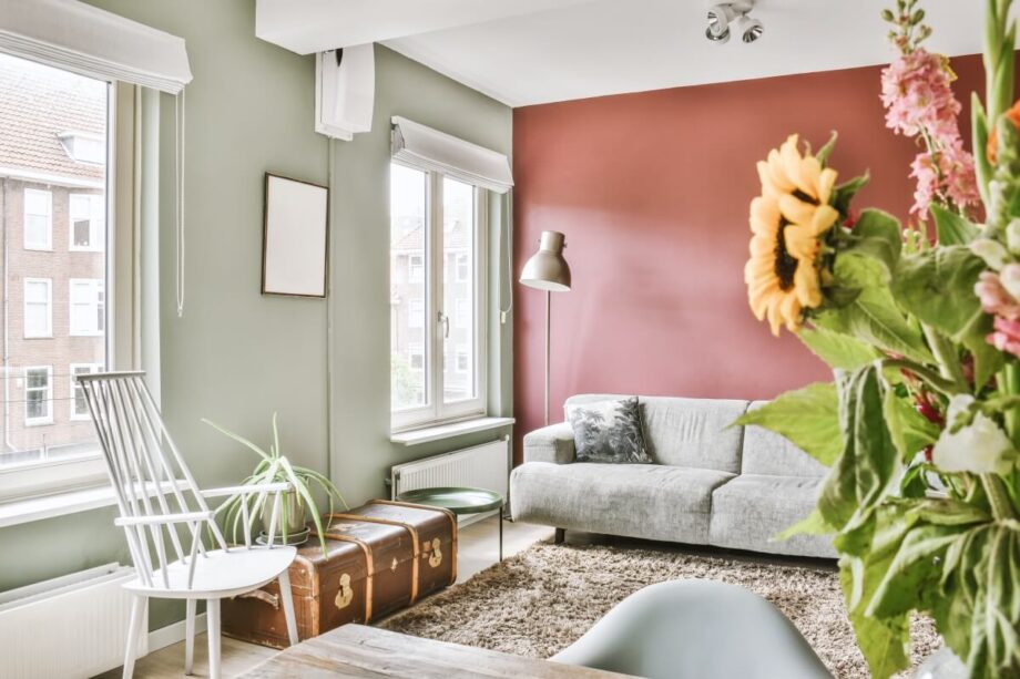 Przytulny salon z kwiatami, kanapą i nowoczesnym wystrojem, idealny przykład na sprzedaż nieruchomości na rynku wtórnym.