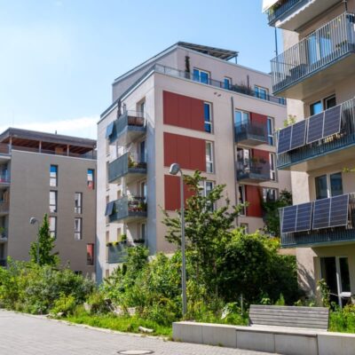 Nowoczesne budynki z panelami słonecznymi na balkonach odzwierciedlają trendy w budownictwie mieszkaniowym.