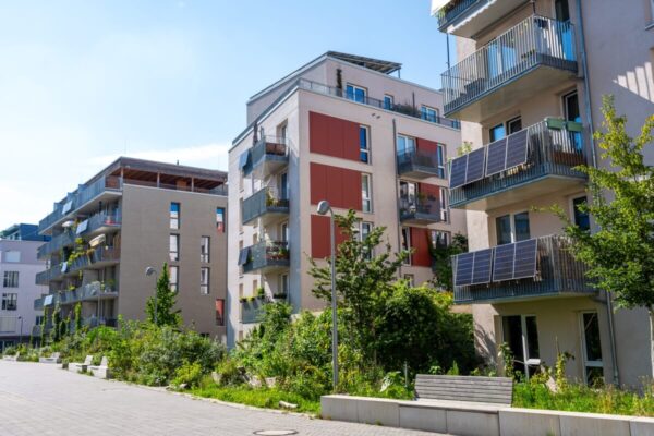 Nowoczesne budynki z panelami słonecznymi na balkonach odzwierciedlają trendy w budownictwie mieszkaniowym.