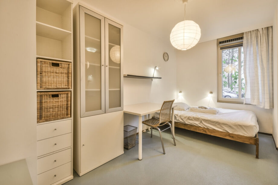 Jasny pokój z łóżkiem, biurkiem i nowoczesnymi rozwiązaniami w zakresie izolacji termicznej.