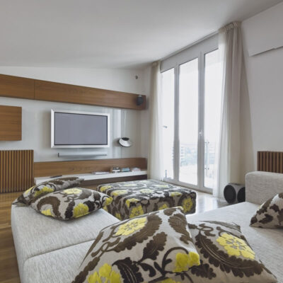 Przestronny salon w nowoczesnych mieszkaniach w centrum miasta z dużymi oknami i eleganckim wystrojem.