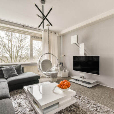 Stylowy salon z nowoczesnym wystrojem, gdzie warto uwzględnić dodatkowe koszty przy kupnie mieszkania.