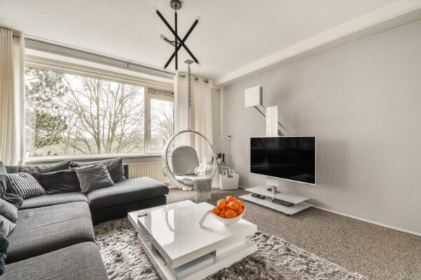 Stylowy salon z nowoczesnym wystrojem, gdzie warto uwzględnić dodatkowe koszty przy kupnie mieszkania.