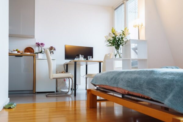 Minimalistyczne wnętrze pokoju zachęca do zakupu mieszkania na rynku wtórnym.